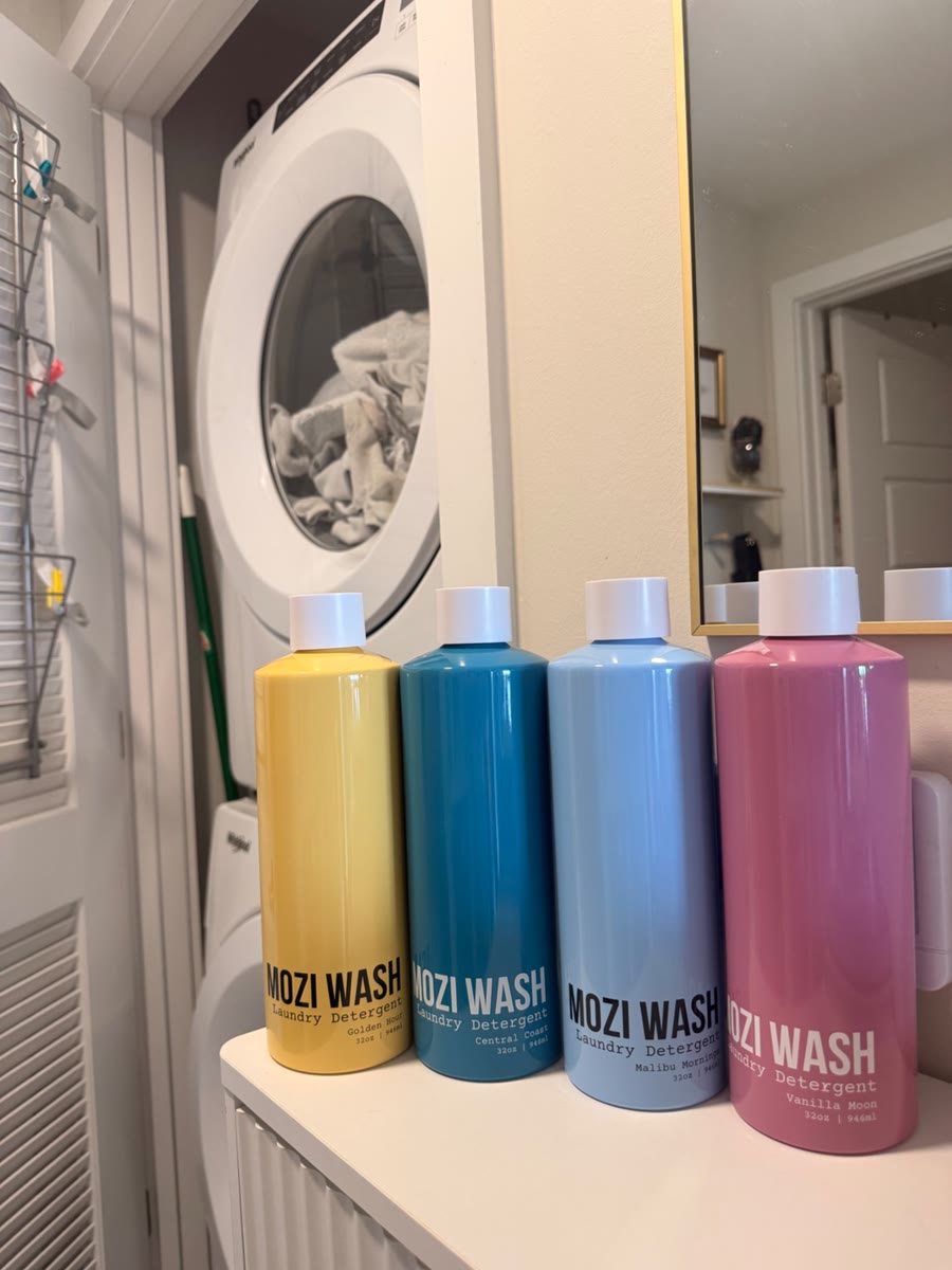 Four Mozi Wash laundry detergent bottles in a laundry room