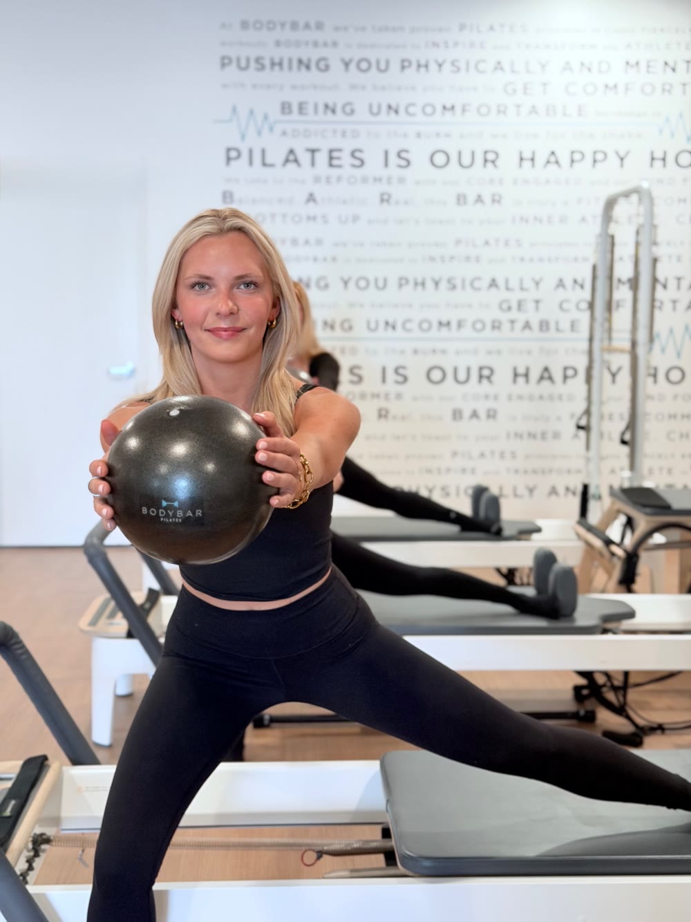 Molly teaching Pilates at BODYBAR, holding a Pilates ball