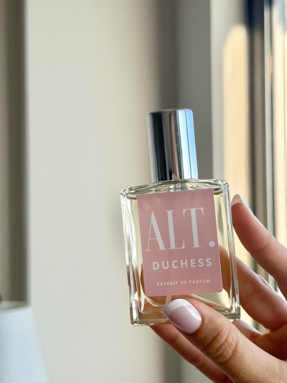 Hand holding a bottle of ALT Duchess perfume