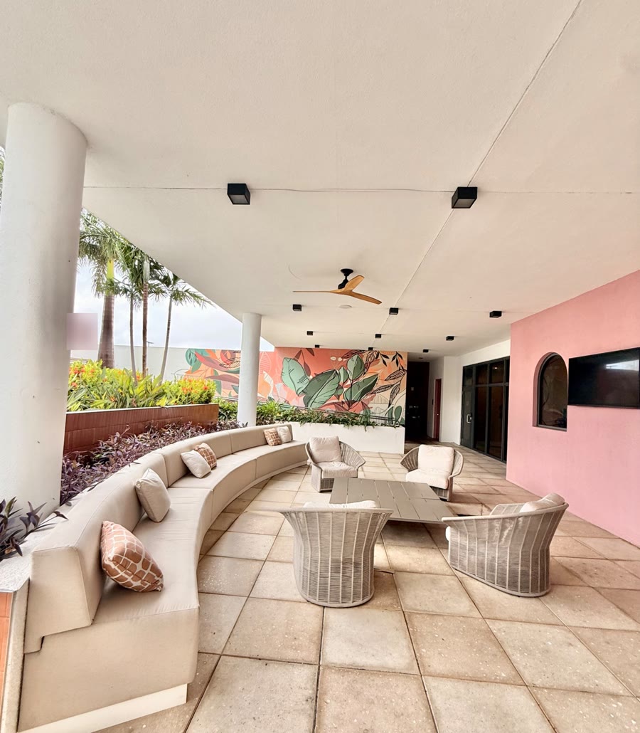 Covered outdoor lounge with a tropical mural