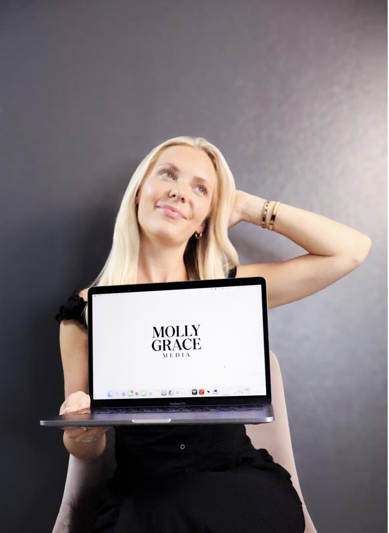Molly holding a laptop showing the Molly Grace Media logo