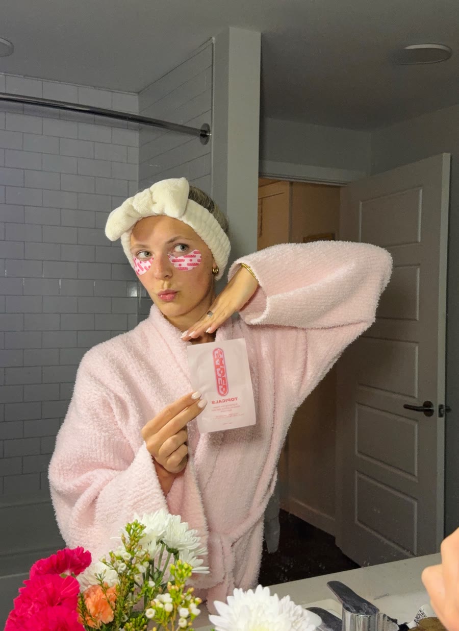 Molly in a pink robe wearing Topicals eye patches