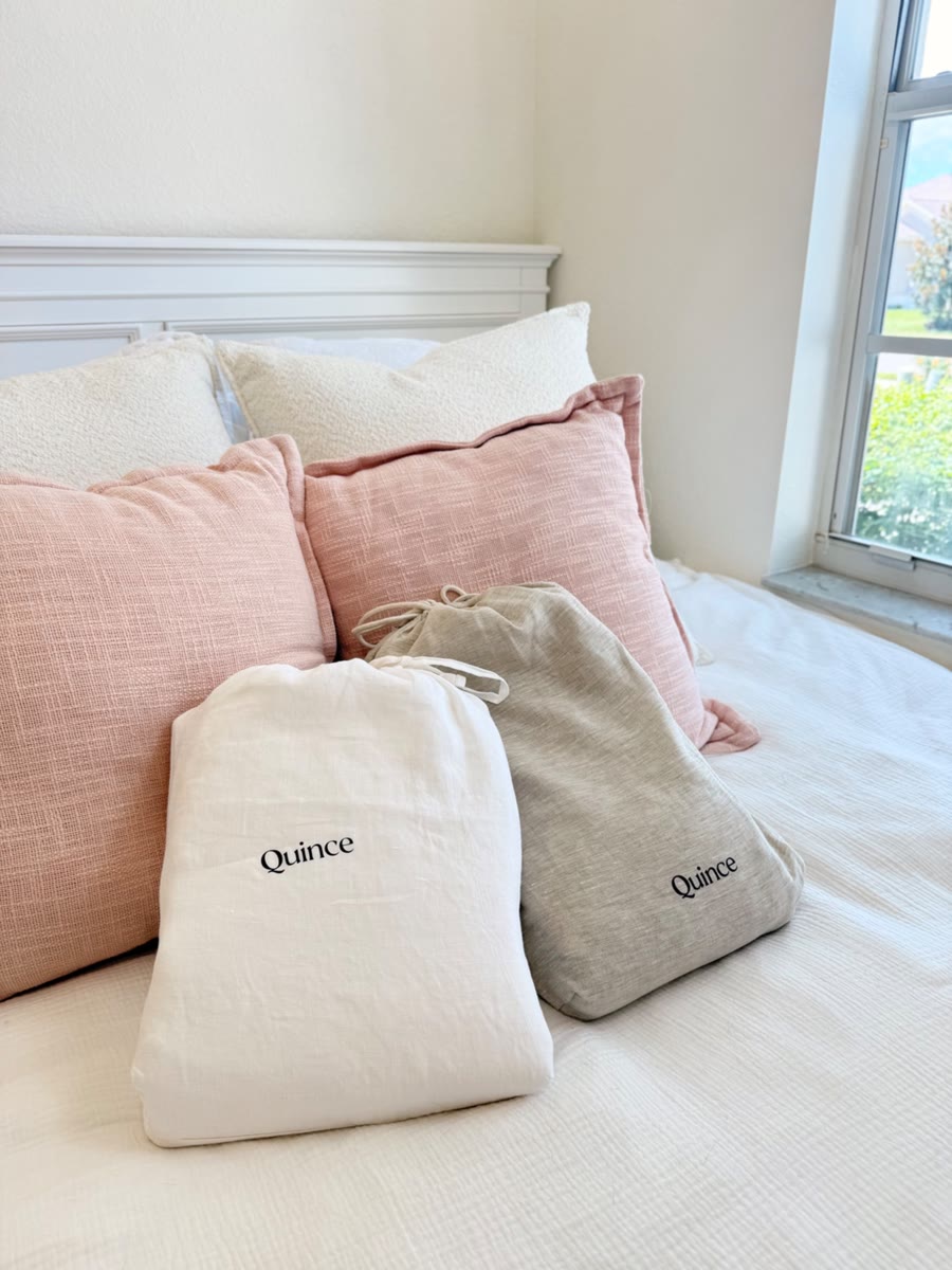 Quince linen bedding bags on a bed with pink pillows